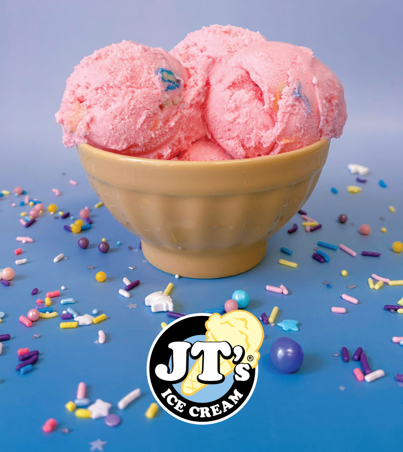 A bowl with three scoops of yummy JT's pink bubble gum ice cream in a bowl surrounded by sprinkles.